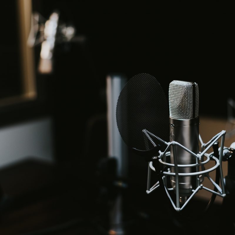 Image shows academic podcast equipment setup with microphone.