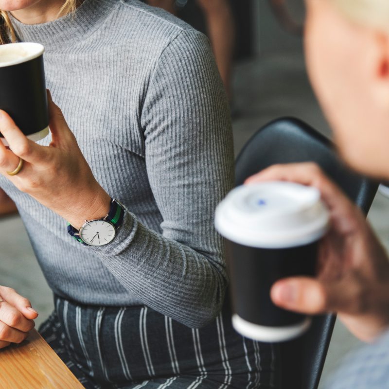 Image shows two women having a conversation over coffee.